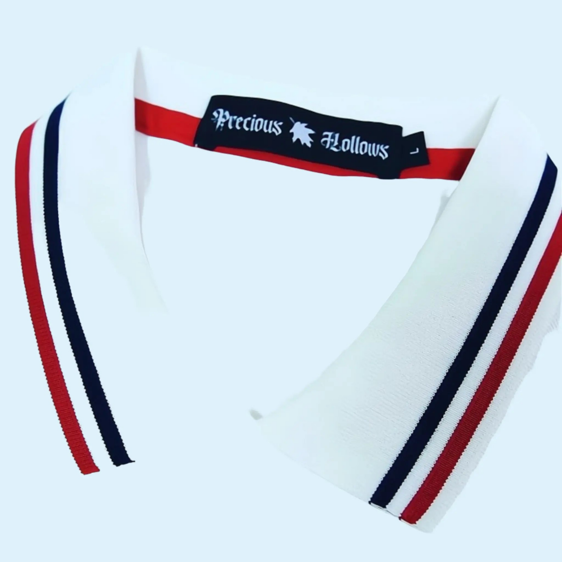 Close of a polo collar with red and navy blue stripes and neck label.#color_white