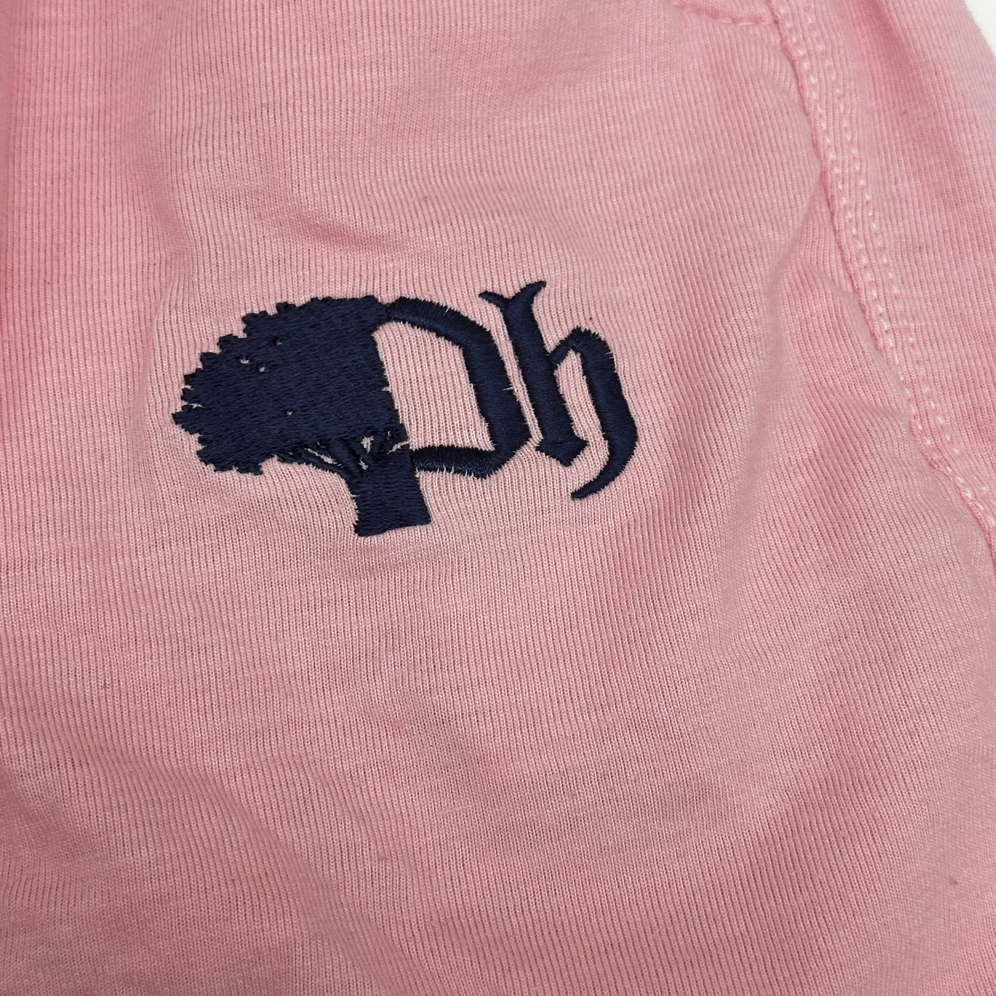 Pink fabric with navy blue embroidered design.