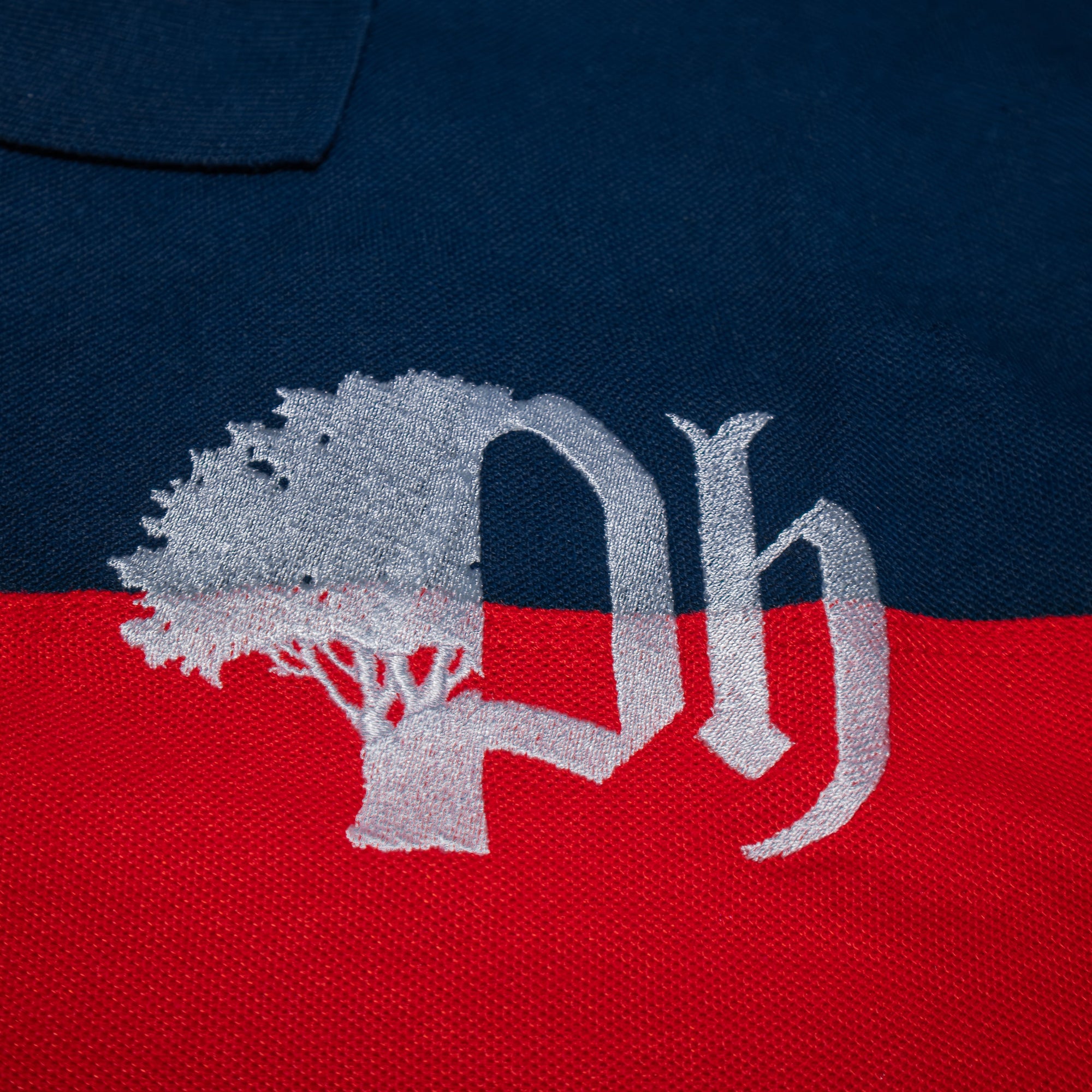 Close-up of a logo on a navy blue and red fabric.