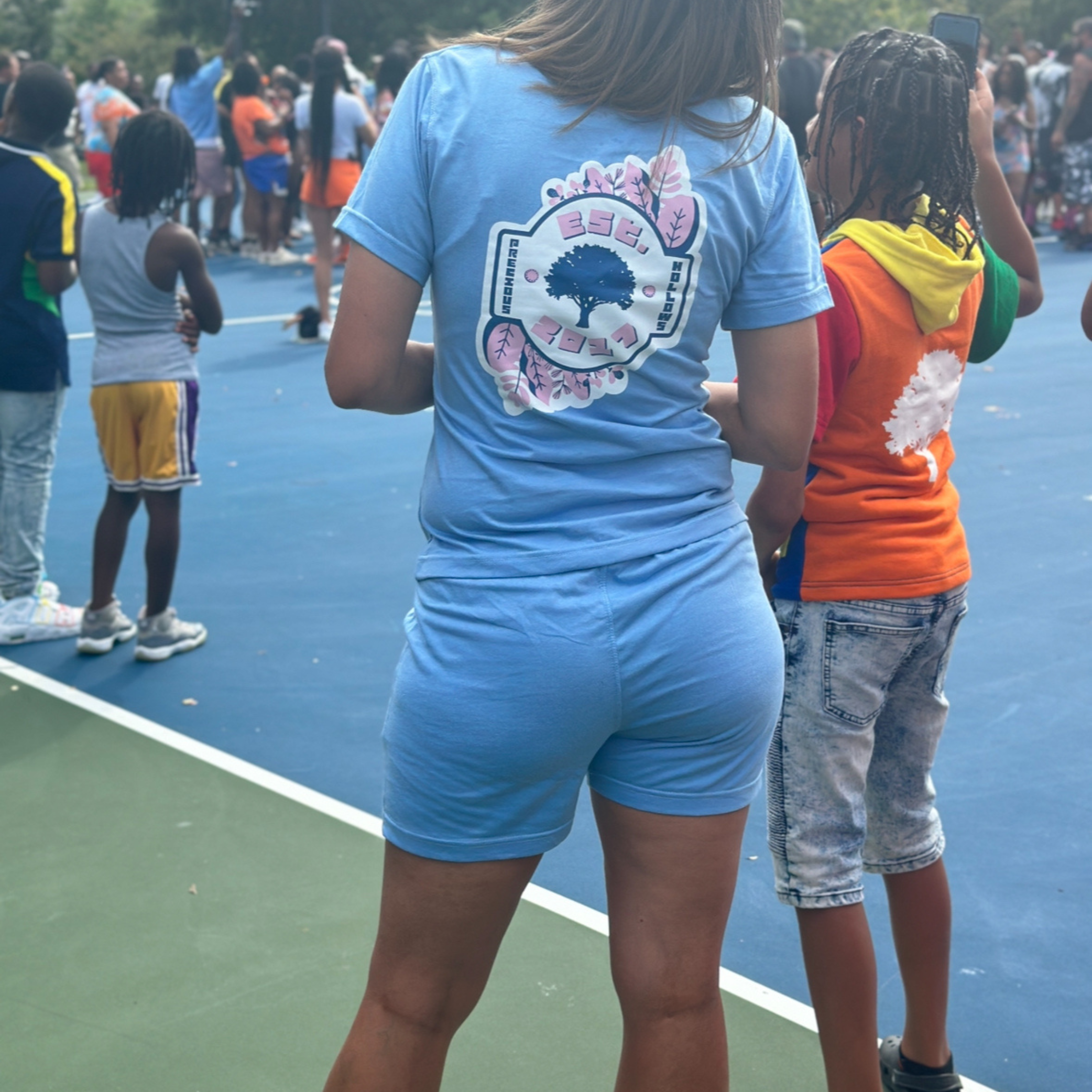 Woman wearing light blue out with a logo on the back