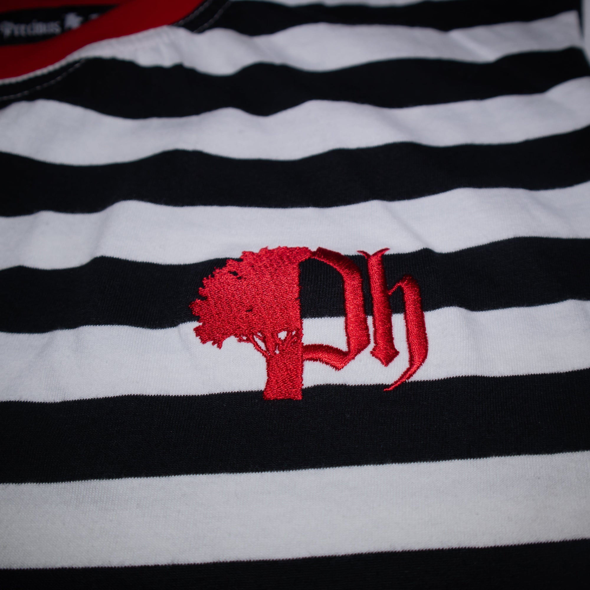Black and white striped shirt with a red logo.