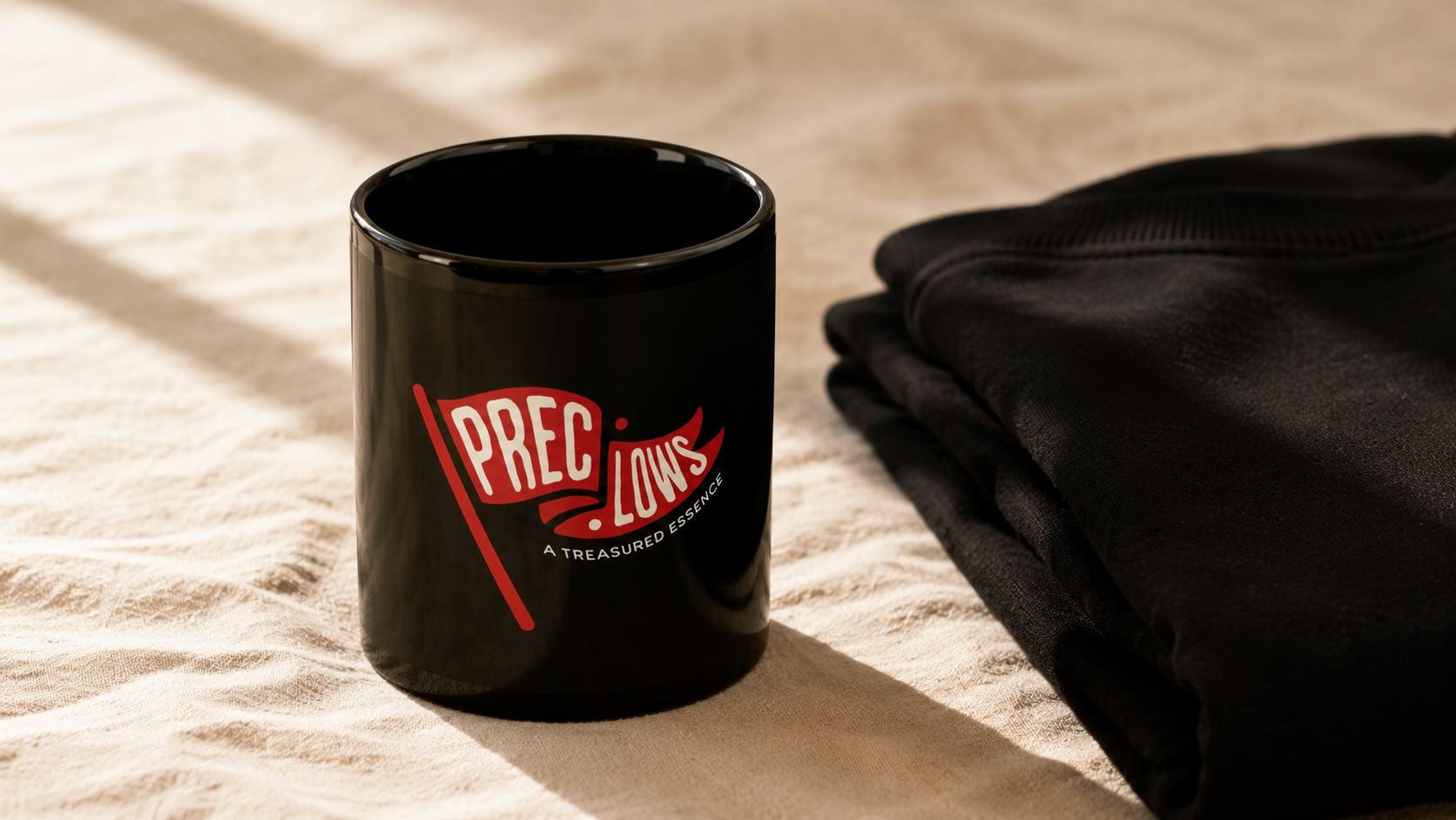 Precious Hollows mug and folded sweater in a warm still life