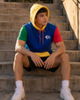Model wearing the Primary Block Hoodie in urban light