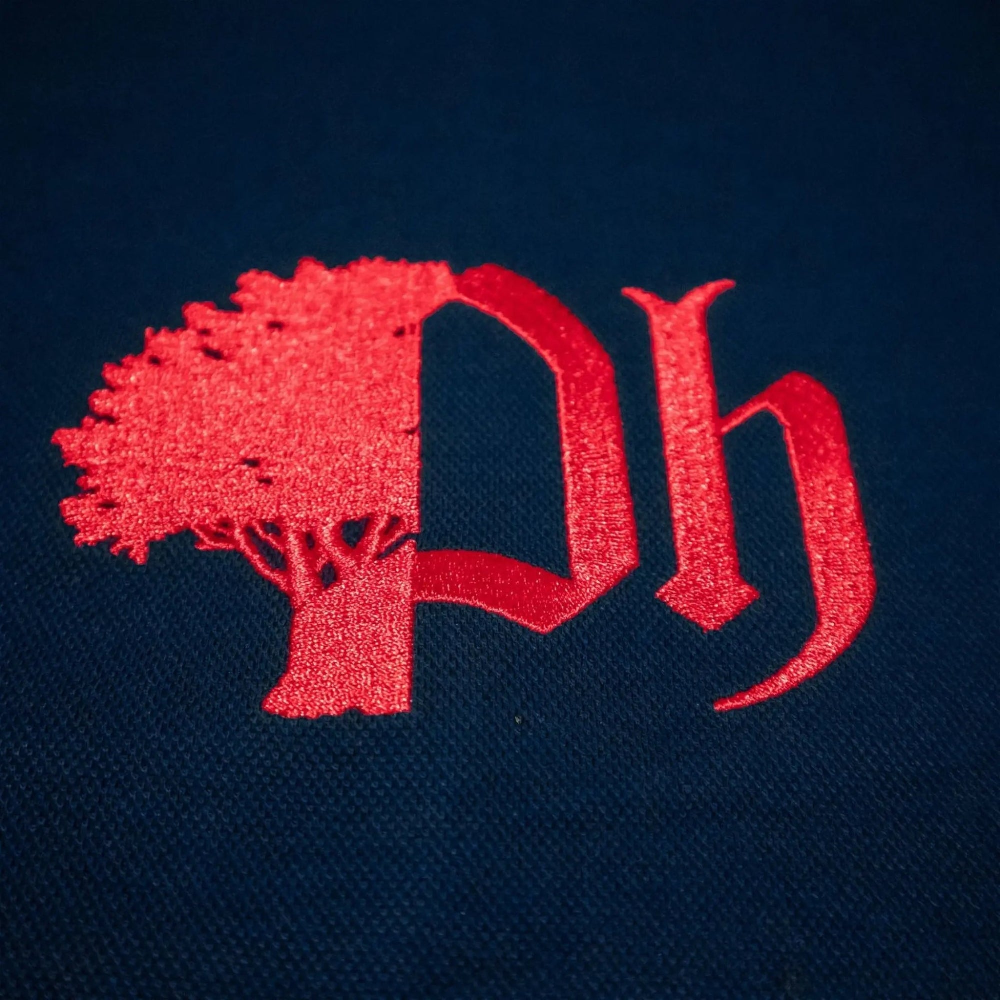 Embroidery image of red logo close up.#color_navy