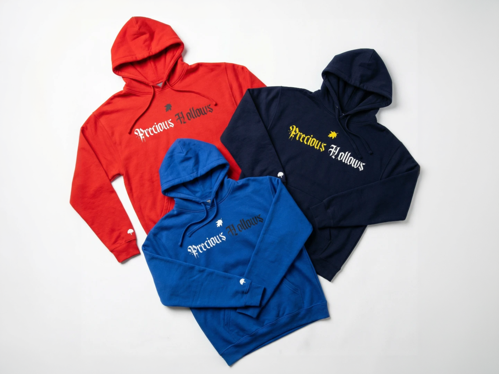 Three hoodies in red, blue, and navy with 'Precious Hollows' branding on a white background.