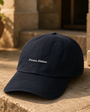 Signature Script Cap in warm courtyard light