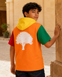 Young model wearing the Junior Block Hoodie in a sunny courtyard