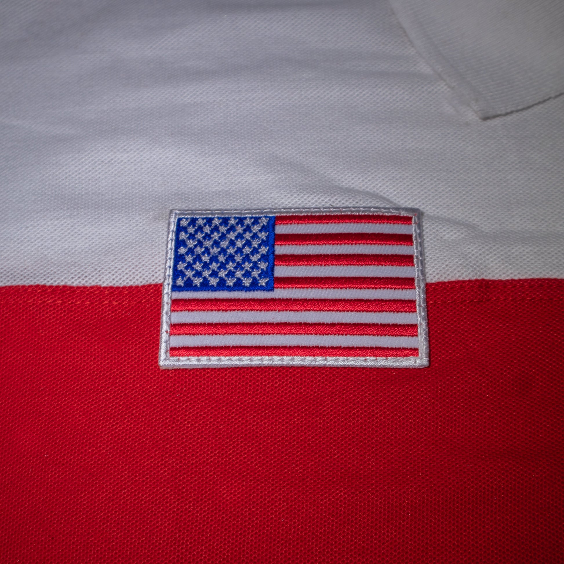 American flag patch on a red and white fabric.#color_white-stripes
