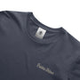 Navy blue t-shirt with 'Precious Hollows' embroidery and a brand label on a white background