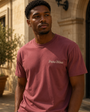 Model wearing the Signature Script Tee in a sunlit courtyard