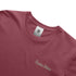 Close-up of a maroon t-shirt with 'Precious Hollows' text and a brand tag on a white background