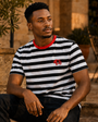 Model wearing the District Stripe Tee in a courtyard