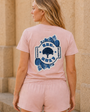 Model wearing the pink Weekend Resort Set on stone steps
